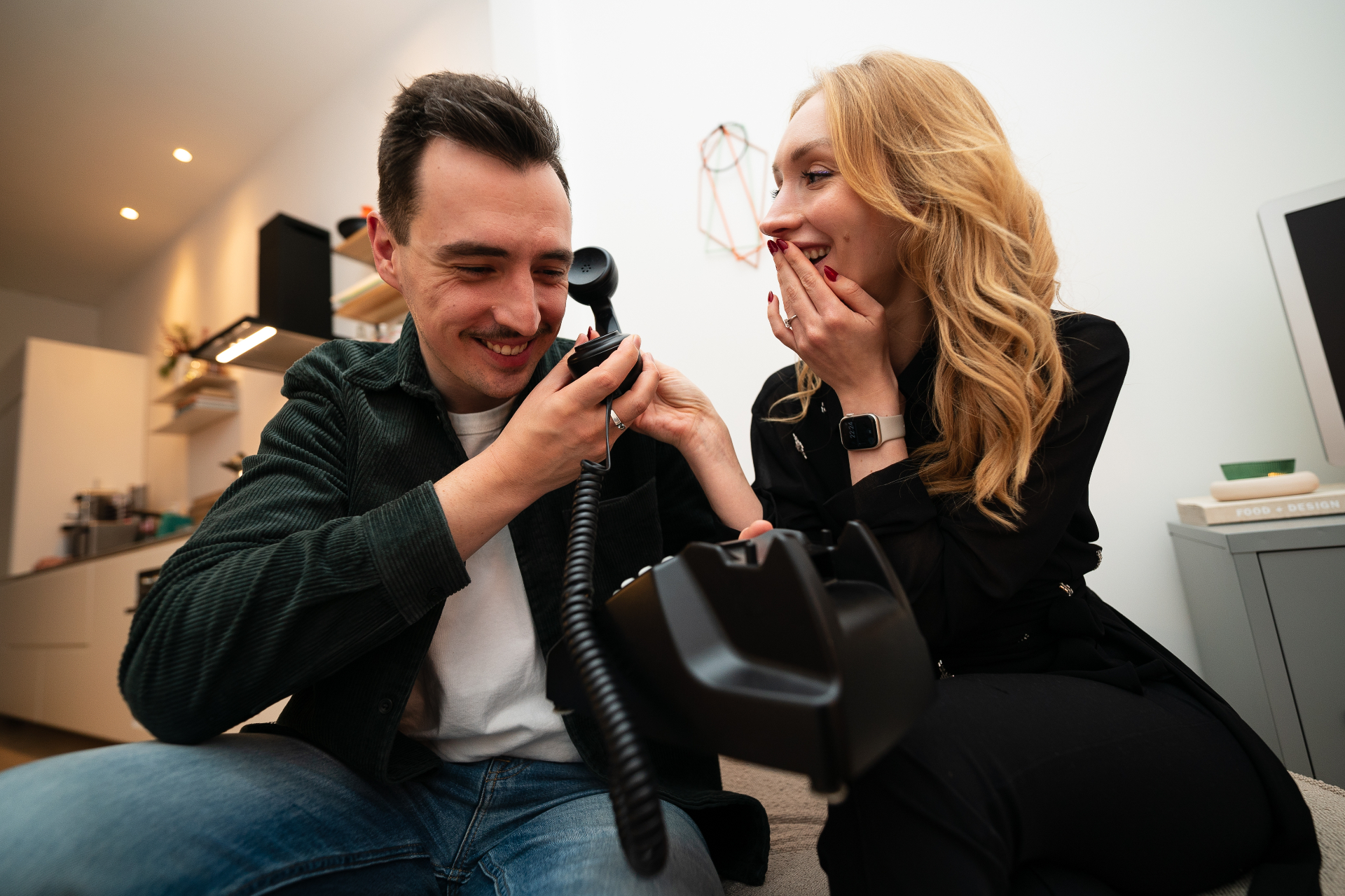 Twee mensen luisteren samen naar een Sound Story via een vintage telefoon